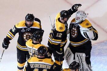 BOSTON, MA - JUNE 08:  Tim Thomas #30 of the Boston Bruins celebrates with his teammates Dennis Seidenberg #44, Johnny Boychuk #55 and Tomas Kaberle #12 after defeating the Vancouver Canucks in Game Four of the 2011 NHL Stanley Cup Final at TD Garden on J