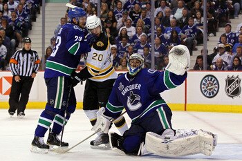 VANCOUVER, BC - JUNE 10:  Alexander Edler #23 of the Vancouver Canucks checks Daniel Paille #20 of the Boston Bruins in front of Roberto Luongo #1 during Game Five of the 2011 NHL Stanley Cup Final at Rogers Arena on June 10, 2011 in Vancouver, British Co