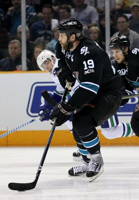 SAN JOSE, CA - MAY 22:  Joe Thornton #19 of the San Jose Sharks skates the puck out of the defensive zone as Alex Burrows #14 of the Vancouver Canucks keeps pace in the first period in Game Four of the Western Conference Finals during the 2011 Stanley Cup