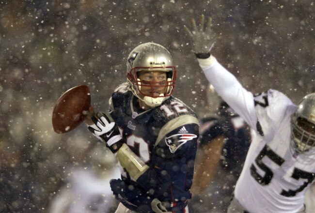 19 Jan 2002:  Quarterback Tom Brady #12 of the New England Patriots scrambles against the defense of Rod Coleman #57 of the Oakland Raiders during the AFC playoff game at Foxboro Stadium in Foxboro, Massachuesetts. The Patriots came from behind to win 16-