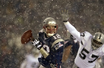 19 Jan 2002:  Quarterback Tom Brady #12 of the New England Patriots scrambles against the defense of Rod Coleman #57 of the Oakland Raiders during the AFC playoff game at Foxboro Stadium in Foxboro, Massachuesetts. The Patriots came from behind to win 16-