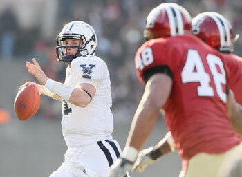 CAMBRIDGE, MA - NOVEMBER 20:  Patrick Witt #11 of the Yale Bulldogs looks to pass as Josue Ortiz of the Harvard Crimson defends on November 20, 2010 at Harvard Stadium in Cambridge, Massachusetts.  Harvard defeated Yale 28-21.  (Photo by Elsa/Getty Images