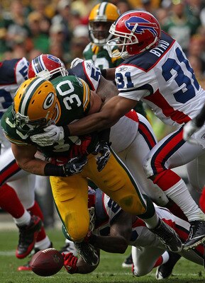 GREEN BAY, WI - SEPTEMBER 19: John Kuhn #30 of the Green Bay Packers fumbles the ball as he is hit by members of the Buffalo Bills defense including Jarius Byrd #31 at Lambeau Field on September 19, 2010 in Green Bay, Wisconsin. The Packers defeated the B