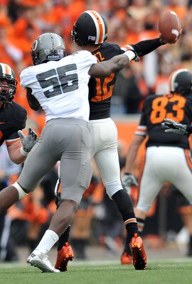 CORVALLIS, OR - DECEMBER 4: Quarterback Ryan Katz #12 of the Oregon State Beavers is hit as he throws the ball by Josh Kaddu #56 of the Oregon Ducks in the second quarter of the game at Reser Stadium on December 4, 2010 in Corvallis, Oregon. (Photo by Ste