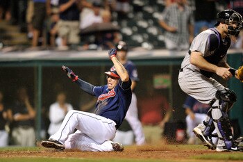 CLEVELAND, OH - JUNE 21:  Asdrubal Cabrera #13 of the Cleveland Indians slides across home plate to score the game tying run in the eighth inning against the Colorado Rockies at Progressive Field on June 21, 2011 in Cleveland, Ohio. Colorado went on to wi