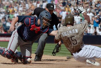 SAN DIEGO, CA - JUNE 26: Jesus Guzman #15 of the San Diego Padres scores past the tag of David Ross #8 of the Atlanta Braves during the eighth inning of a baseball game at Petco Park on June 26, 2011 in San Diego, California.  (Photo by Denis Poroy/Getty