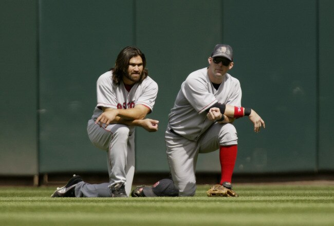 SEATTLE - JULY 20:  Johnny Damon #18 and Trot Nixon #7 of the Boston Red Sox take a knee in the outfield during a break in the game against the Seattle Mariners on July 20, 2004 at Safeco Field in Seattle, Washington.  The Red Sox defeated the Mariners 9-