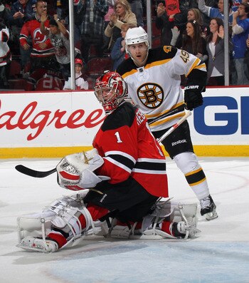 NEWARK, NJ - APRIL 10: Rich Peverley #49 of the Boston Bruins and Johan Hedberg #1 of the New Jersey Devils watch a shot go wide of the net at the Prudential Center on April 10, 2011 in Newark, New Jersey. The Devils defeated the Bruins 3-2. (Photo by Bru