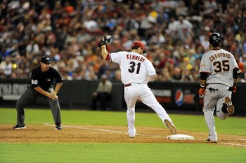 PHOENIX - JUNE 16: Pitcher Ian Kennedy #31 of the Arizona Diamondbacks makes covers first base as Brandon Crawford #35 of the San Francisco Giants runs up the base line at Chase Field on June 16, 2011 in Phoenix, Arizona.  (Photo by Norm Hall/Getty Images