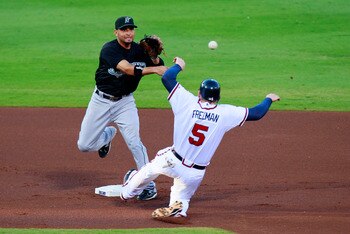 ATLANTA, GA - JULY 29:  Omar Infante #13 of the Florida Marlins turns a double play over Freddie Freeman #5 of the Atlanta Braves in the first inning at Turner Field on July 29, 2011 in Atlanta, Georgia.  (Photo by Kevin C. Cox/Getty Images)