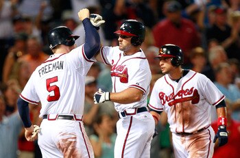 ATLANTA, GA - JULY 29:  Dan Uggla #26 of the Atlanta Braves celebrates his three-run homer in the seventh inning against the Florida Marlins with Freddie Freeman #5 and Martin Prado #14 at Turner Field on July 29, 2011 in Atlanta, Georgia.  (Photo by Kevi