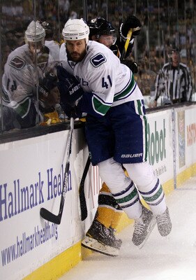 BOSTON, MA - JUNE 13:  Andrew Alberts #41 of the Vancouver Canucks collides with Tomas Kaberle #12 of the Boston Bruins during Game Six of the 2011 NHL Stanley Cup Final at TD Garden on June 13, 2011 in Boston, Massachusetts.  (Photo by Elsa/Getty Images)