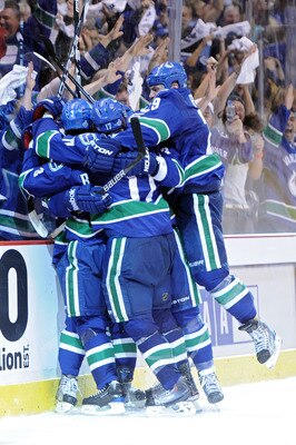 VANCOUVER, BC - JUNE 01:  Raffi Torres #13 of the Vancouver Canucks celebrates with his teammates Kevin Bieksa #3, Ryan Kesler #17 and Aaron Rome #29 after he scored a goal late in the third period against Tim Thomas #30 of the Boston Bruins during game o