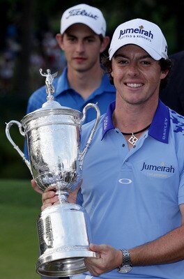 BETHESDA, MD - JUNE 19:  Rory McIlroy of Northern Ireland poses with the trophy, as amateur Patrick Cantlay looks on, after his eight-stroke victory on the 18th green during the 111th U.S. Open at Congressional Country Club on June 19, 2011 in Bethesda, M