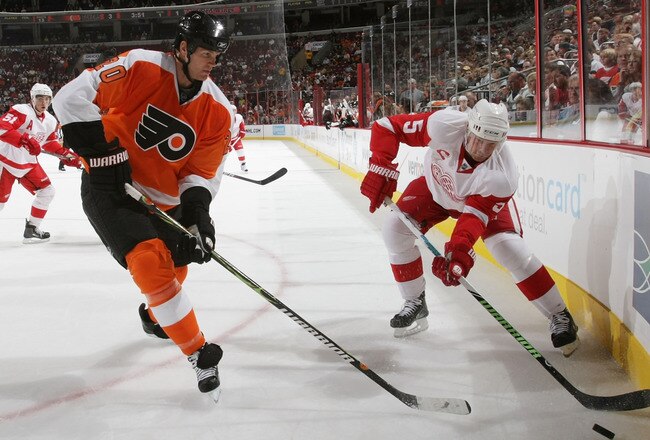 PHILADELPHIA - SEPTEMBER 22: Nicklas Lidstrom #5 of the Detroit Red Wings shoots the puck past Chris Pronger #20 of the Philadelphia Flyers during preseason action at the Wachovia Center on September 22, 2009 in Philadelphia, Pennsylvania.  (Photo by Bruc