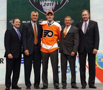 ST PAUL, MN - JUNE 24:  Eighth overall pick 	Sean Couturier by the Philadelphia Flyers stands with General Manager Paul Holmgren of the Philadelphia Flyers and a members of the Philadelphia Flyers organization onstage during day one of the 2011 NHL Entry