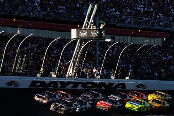 DAYTONA BEACH, FL - FEBRUARY 20:  Ryan Newman, driver of the #39 U.S. Army Chevrolet, and Denny Hamlin, driver of the #11 FedEx Toyota, lead a pack of cars past the green flag for a restart during the NASCAR Sprint Cup Series Daytona 500 at Daytona Intern