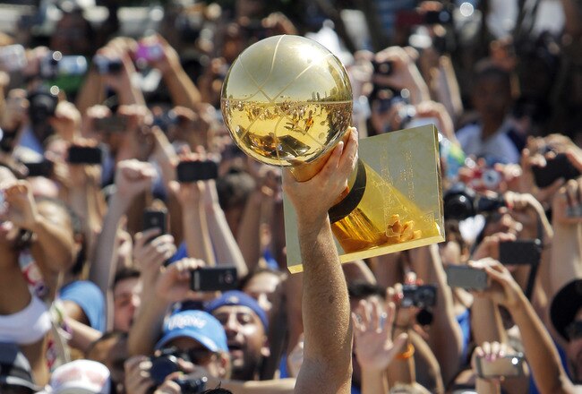 DALLAS, TX - JUNE 16: Dallas Mavericks owner Mark Cuban hoists the Larry O'Brien Trophy up for fans during the Dallas Mavericks Victory Parade on June 16, 2011 in Dallas, Texas. (Photo by Brandon Wade/Getty Images)