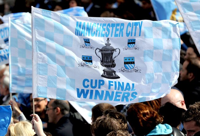 MANCHESTER, ENGLAND - MAY 23:  A Manchester City fan waves a flag during the Manchester City FA Cup Winners Parade at Manchester Town Hall on May 23, 2011 in Manchester, United Kingdom.  (Photo by Chris Brunskill/Getty Images)