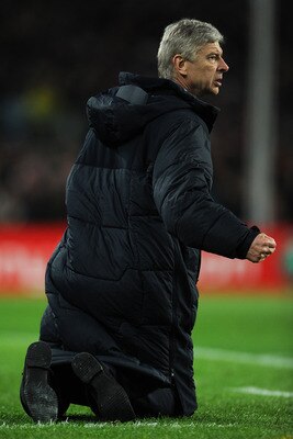 BARCELONA, SPAIN - MARCH 08:  Head coach Arsene Wenger of Arsenal sits on his knees on the pitch as he reacts to his players during the UEFA Champions League round of 16 second leg match between Barcelona and Arsenal on March 8, 2011 in Barcelona, Spain. 