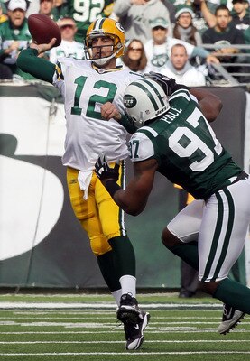 EAST RUTHERFORD, NJ - OCTOBER 31: Aaron Rodgers #12 of the Green Bay Packers throws a pass under pressure from Calvin Pace #97 of the New York Jets on October 31, 2010 at the New Meadowlands Stadium in East Rutherford, New Jersey. (Photo by Jim McIsaac/Ge