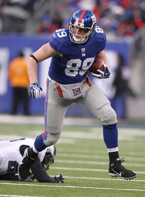 EAST RUTHERFORD, NJ - DECEMBER 19:  Kevin Boss #89 of the New York Giants eludes the tackle of Quintin Mikell #27 of the Philadelphia Eagles during their game on December 19, 2010 at The New Meadowlands Stadium in East Rutherford, New Jersey.  (Photo by A