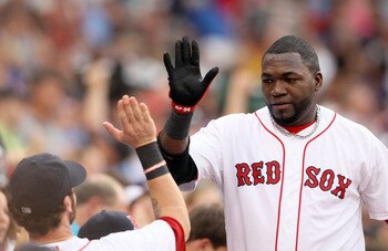 BOSTON, MA - JULY 05:  David Ortiz #34 of the Boston Red Sox is congratulated by teammates in the dugout after he scored a run off a hit by teammate Jason Varitek in the second inning against the Toronto Blue Jays on July 5, 2011 at Feway Park in Boston,