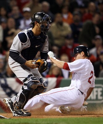 BOSTON - APRIL 06:  Jacoby Ellsbury #2 of the Boston Red Sox slides home safely past Jorge Posada #20 of the New York Yankees in the first inning on April 6, 2010 at Fenway Park in Boston, Massachusetts.  (Photo by Elsa/Getty Images)