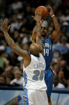 DENVER - JANUARY 17:  Jameer Nelson #14 of the Orlando Magic takes a shot over Anthony Carter #25 of the Denver Nuggets during NBA action at the Pepsi Center on January 17, 2009 in Denver, Colorado. The Magic defeated the Nuggets 106-88. NOTE TO USER: Use