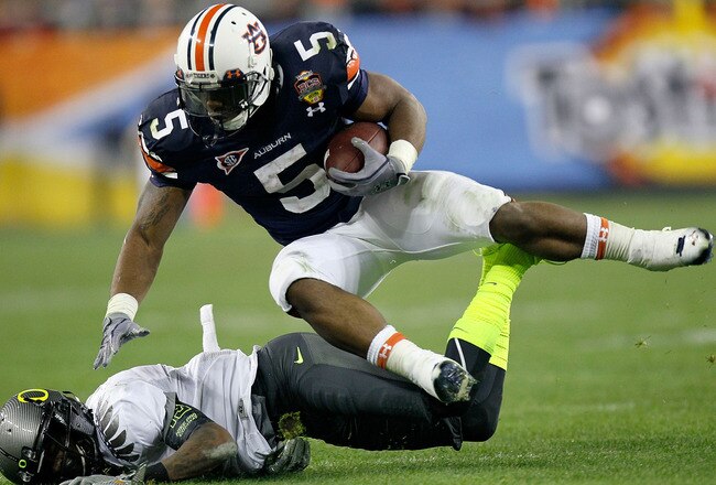 GLENDALE, AZ - JANUARY 10:  Michael Dyer #5 of the Auburn Tigers is tackled by Tevin Cheever #12 of the Oregon Ducks in the third quarter of the Tostitos BCS National Championship Game at University of Phoenix Stadium on January 10, 2011 in Glendale, Ariz