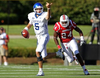 LOUISVILLE, KY - SEPTEMBER 04:  Mike Hartline #5 of the Kentucky Wildcats runs with the ball while pursued by Daniel Brown #24 of the Louisville Cardinals during the game at Papa John's Cardinal Stadium on September 4, 2010 in Louisville, Kentucky.  (Phot