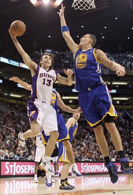 PHOENIX, AZ - FEBRUARY 10:  Steve Nash #13 of the Phoenix Suns lays up a shot past Andris Biedrins #15 of the Golden State Warriors during the NBA game at US Airways Center on February 10, 2011 in Phoenix, Arizona.  NOTE TO USER: User expressly acknowledg