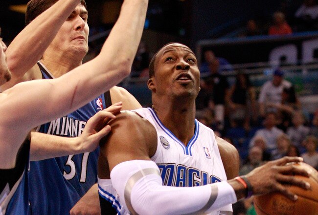 ORLANDO, FL - NOVEMBER 03:  Dwight Howard #12 of the Orlando Migic drives against Darko Milicic #31 and Kevin Love #42 of the Minnesota Timberwolves during the game at Amway Arena on November 3, 2010 in Orlando, Florida.  NOTE TO USER: User expressly ackn