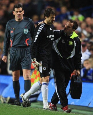 LONDON - APRIL 08:  Carlo Cudicini of Chelsea limps off with the physio as assistant referee Carsten Kadach looks on during the UEFA Champions League Quarter Final 2nd Leg match between Chelsea and Fenerbahce at Stamford Bridge on April 8, 2008 in London,