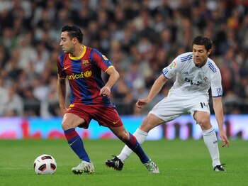 MADRID, SPAIN - APRIL 16:  Xavi Hernandez (L) of Barcelona controls the ball besides Xabi Alonso of Real Madrid during the la Liga match between Real Madrid and Barcelona at Estadio Santiago Bernabeu on April 16, 2011 in Madrid, Spain.  (Photo by Jasper J