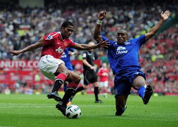 MANCHESTER, ENGLAND - APRIL 23: Sylvain Distin of Everton challenges Antonio Valencia of Manchester United during the Barclays Premier League match between Manchester United and Everton at Old Trafford on April 23, 2011 in Manchester, England.  (Photo by