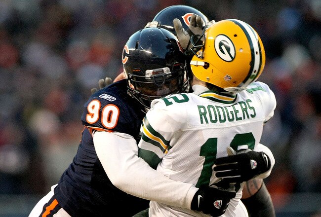 CHICAGO, IL - JANUARY 23:  Quarterback Aaron Rodgers #12 of the Green Bay Packers is hit by Julius Peppers #90 of the Chicago Bears in the helmet as Peppers was called for a personal foul in the fourth quarter of the NFC Championship Game at Soldier Field