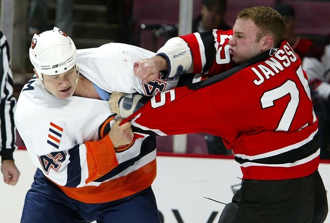 EAST RUTHERFORD, NJ - NOVEMBER 02:  Cam Janssen #25 of the New Jersey Devils throws a puch against Arron Asham #45 of the New York Islanders during their game on November 2, 2006 at Continental Airlines Arena in East Rutherford, New Jersey.  (Photo by Jim