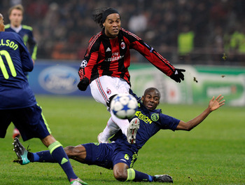 MILAN, ITALY - DECEMBER 08:  Ronaldinho of AC Milan and Eyong Enoh of AFC Ajax compete for the ball during the UEFA Champions League Group G match between AC Milan and AFC Ajax at Stadio Giuseppe Meazza on December 8, 2010 in Milan, Italy.  (Photo by Clau