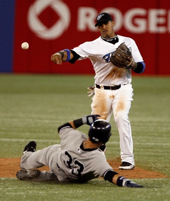 TORONTO, CANADA - JULY 15: Yunel Escobar #5 of the Toronto Blue Jays makes the double play on Nick Swisher #33 of the New York Yankees during MLB action at The Rogers Centre July 15, 2011 in Toronto, Ontario, Canada. (Photo by Abelimages/Getty Images)