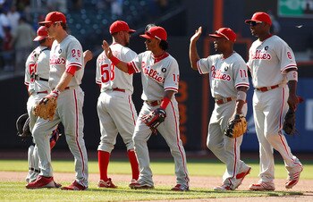 NEW YORK, NY - JULY 17:  Michael Martinez #19 of the Philadelphia Phillies celebrates with teammates Jimmy Rollins #11, Chase Utley #26 and Ryan Howard #6 after defeating the New York Mets on July 17, 2011 at Citi Field in the Flushing neighborhood of the