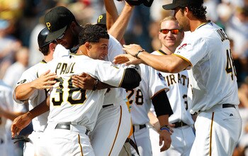 PITTSBURGH - JULY 24:  Xavier Paul #38 of the Pittsburgh Pirates is congratulated by teammates James McDonald #53 and Garrett Jones #46 after scoring the game winning run in the 10th inning against the St Louis Cardinals during the game on July 24, 2011 a