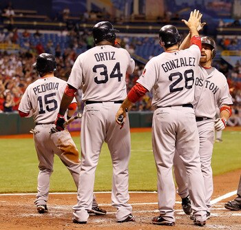 ST PETERSBURG, FL - JUNE 15:  Infielder Kevin Youkilis #20 of the Boston Red Sox is congratulated by Adrian Gonzalez #28, David Ortiz #34 and Dustin Pedroia #15 after his three run home run in the seventh inning against the Tampa Bay Rays during the game