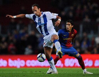 BARCELONA, SPAIN - APRIL 11:  Ersen Martin (L) of Recreativo Huelva battles for the ball with Martin Caceres of Barcelona during the La Liga match between Barcelona and  Recreativo Huelva at the Camp Nou Stadium on April 11, 2009 in Barcelona, Spain. Barc