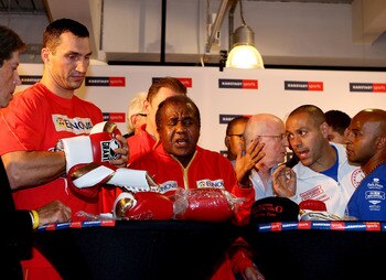 HAMBURG, GERMANY - JULY 01:  Wladimir Klitschko (L) and his trainer Emanuel Steward (C) discuss gloves with the trainer of David Haye Adam Booth during the weigh in for his upcoming heavy weight title fight with David Haye at Karstadt Sports shopping cent
