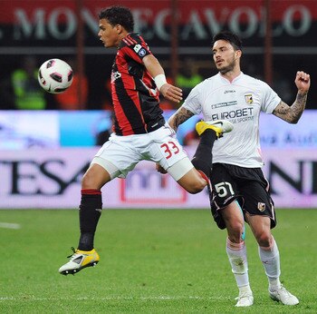 MILAN, ITALY - APRIL 20:  Thiago Silva (L) of Milan jumps for the ball as Mauricio Pinilla of Palermo tackles during the TIM Cup semifinal match between AC Milan and US Citta di Palermo at Stadio Giuseppe Meazza on April 20, 2011 in Milan, Italy.  (Photo