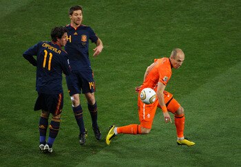 JOHANNESBURG, SOUTH AFRICA - JULY 11:  Arjen Robben of the Netherlands runs with the ball as Joan Capdevila and Xabi Alonso of Spain looks on during the 2010 FIFA World Cup South Africa Final match between Netherlands and Spain at Soccer City Stadium on J