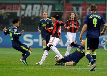 MILAN, ITALY - DECEMBER 08:  Ronaldinho of AC Milan and Demy de Zeeuw (R) of AFC Ajax compete for the ball during the UEFA Champions League Group G match between AC Milan and AFC Ajax at Stadio Giuseppe Meazza on December 8, 2010 in Milan, Italy.  (Photo