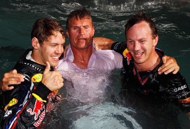 MONTE CARLO, MONACO - MAY 29:  Race winner Sebastian Vettel (L) of Germany and Red Bull Racing and Red Bull Racing Team Principal Christian Horner (R) take BBC F1 commentator David Coulthard (C) into the Red Bull Racing Energy Station swimming pool as the