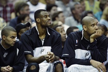 SAN ANTONIO - MAY 19:  (Left to Right) Tony Parker #9, David Robinson #50, and Tim Duncan #21 of the San Antonio Spurs sits on the bench in Game one of the Western Conference Finals against the Dallas Mavericks during the 2003 NBA Playoffs at SBC Center o